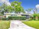 Inviting single-story home with mature landscaping, blue skies and screened porch at 515 Scenic St, Leesburg, FL 34748