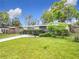 Landscaped front yard with green lawn and mature trees offers inviting curb appeal at 515 Scenic St, Leesburg, FL 34748