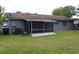 Exterior view of backyard with screened-in porch and grassy area at 5177 Edwina St, Orlando, FL 32811
