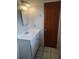 Standard bathroom featuring a sink with chrome fixtures, a mirror, and a wooden door at 5177 Edwina St, Orlando, FL 32811