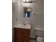 Bathroom featuring a toilet, sink with vanity and decorative wall mirror at 5177 Edwina St, Orlando, FL 32811