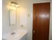 Standard bathroom featuring a sink with chrome fixtures, a mirror, and a wooden door at 5177 Edwina St, Orlando, FL 32811