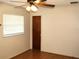 A bedroom featuring a ceiling fan and natural light from two windows with wood-look flooring at 5177 Edwina St, Orlando, FL 32811