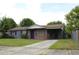 Charming single-story home features a brick and gray painted exterior, an open carport, and a well-maintained front lawn at 5177 Edwina St, Orlando, FL 32811