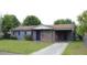 Charming single-story home features a brick and gray painted exterior, an open carport, and a well-maintained front lawn at 5177 Edwina St, Orlando, FL 32811
