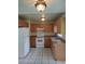 This kitchen features tile floors, light wood cabinetry, an electric range, and a standard size refrigerator at 5177 Edwina St, Orlando, FL 32811