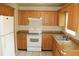This kitchen features tile floors, light wood cabinetry, an electric range, and a standard size refrigerator at 5177 Edwina St, Orlando, FL 32811
