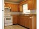 This kitchen features tile floors, light wood cabinetry, an electric range, and a standard size refrigerator at 5177 Edwina St, Orlando, FL 32811