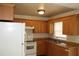 This kitchen features tile floors, light wood cabinetry, an electric range, and a standard size refrigerator at 5177 Edwina St, Orlando, FL 32811