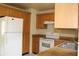 This kitchen features tile floors, light wood cabinetry, an electric range, and a standard size refrigerator at 5177 Edwina St, Orlando, FL 32811
