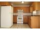 This kitchen features tile floors, light wood cabinetry, an electric range, and a standard size refrigerator at 5177 Edwina St, Orlando, FL 32811