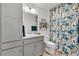 Bright bathroom features a vanity with storage, toilet, and tub with a floral shower curtain at 5726 Leboeuf Ln, The Villages, FL 32163