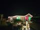 Night shot of a festive home adorned with holiday lights, showcasing its curb appeal and outdoor decorations at 5726 Leboeuf Ln, The Villages, FL 32163