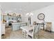 Open-concept kitchen and dining area with stylish lighting, wooden floors, and modern appliances at 5726 Leboeuf Ln, The Villages, FL 32163
