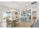 Bright kitchen with a spacious island, dining area, and sliding glass doors leading to the outdoor area at 5726 Leboeuf Ln, The Villages, FL 32163