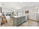 Open-concept kitchen featuring an island with a sink, modern appliances, and seamless flow to the living area at 5726 Leboeuf Ln, The Villages, FL 32163