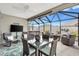 Screened patio features comfortable seating, dining area, TV, and hot tub at 5726 Leboeuf Ln, The Villages, FL 32163