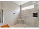 Beautiful glass-enclosed shower with bench, window and modern finishes for a spa-like experience at 5726 Leboeuf Ln, The Villages, FL 32163