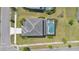 Aerial view of a home featuring a screened-in pool, lush landscaping, and a paved driveway at 598 Marcello Blvd, Kissimmee, FL 34746