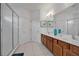 Bathroom featuring double sinks, wood cabinets, a glass shower, and ample storage space at 598 Marcello Blvd, Kissimmee, FL 34746