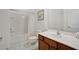 Clean bathroom with a shower-tub combo, white tile, and wood vanity at 598 Marcello Blvd, Kissimmee, FL 34746