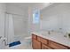 Bright bathroom with a shower-tub combo, white tile, and wood vanity at 598 Marcello Blvd, Kissimmee, FL 34746