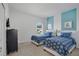 Cozy bedroom with twin beds, light blue accent wall, and a charming decor at 598 Marcello Blvd, Kissimmee, FL 34746