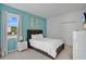 Bright bedroom with a plush bed, light blue accent wall, and natural light from the window at 598 Marcello Blvd, Kissimmee, FL 34746