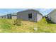 Grassy backyard and side yard area with an exterior view of home's window at 6342 Whittle Ct, The Villages, FL 32163