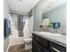 Bathroom with a bathtub and shower combination, toilet, vanity mirror, and granite countertops at 6342 Whittle Ct, The Villages, FL 32163