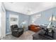 Cozy bedroom featuring blue walls, plush gray carpet, a ceiling fan, and ample natural light at 6342 Whittle Ct, The Villages, FL 32163
