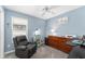 Bedroom featuring blue walls, plush gray carpet, a ceiling fan, and a comfortable recliner at 6342 Whittle Ct, The Villages, FL 32163