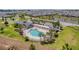 Aerial view featuring a community pool surrounded by ample seating, shaded areas, and well-maintained landscaping at 6342 Whittle Ct, The Villages, FL 32163