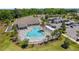 Community pool aerial view, showcasing lounge areas, palm trees, and shaded seating at 6342 Whittle Ct, The Villages, FL 32163