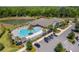 Aerial view of community pool area with palm trees, lounge chairs, and a clubhouse at 6342 Whittle Ct, The Villages, FL 32163