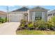 Charming single story home with blue and gray accents, attached garage, and manicured landscaping at 6342 Whittle Ct, The Villages, FL 32163