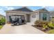 Charming one-story home with two-car garage and golf cart parked on the driveway at 6342 Whittle Ct, The Villages, FL 32163