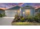 Charming single story home with blue and gray accents, attached garage, and manicured landscaping at 6342 Whittle Ct, The Villages, FL 32163