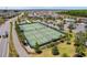 Aerial view of modern pickleball courts, manicured landscaping, and lush greenery in a vibrant community setting at 6342 Whittle Ct, The Villages, FL 32163