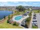 Community pool with palm trees, lounge chairs, and lake views in a well-maintained neighborhood at 6342 Whittle Ct, The Villages, FL 32163
