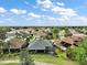 Expansive aerial view showcasing a well-maintained neighborhood with lush landscaping and beautiful homes under a partly cloudy blue sky at 685 Winifred Way, The Villages, FL 32162