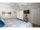This bedroom has a closet with ample space, flat screen TV, and modern flooring for a cozy space at 685 Winifred Way, The Villages, FL 32162