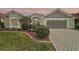 Charming single-story home with a well-manicured lawn and a brick-paved driveway at 685 Winifred Way, The Villages, FL 32162
