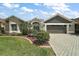 Charming home with well-manicured landscaping, brick driveway, and inviting entrance at 685 Winifred Way, The Villages, FL 32162