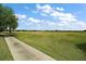 Scenic view of the golf course from a paved walking path with lush greenery at 685 Winifred Way, The Villages, FL 32162