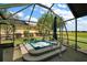 Screened-in hot tub overlooking a golf course with tropical landscaping and bright blue sky at 685 Winifred Way, The Villages, FL 32162
