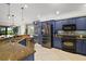 Stylish kitchen with blue cabinets, stainless steel appliances, and granite countertops at 685 Winifred Way, The Villages, FL 32162