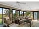 Bright sunroom with large windows offering scenic views, cozy furniture, and ceiling fans at 685 Winifred Way, The Villages, FL 32162