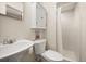 Well-lit bathroom with pedestal sink, toilet, and a shower behind a curtain at 7115 Lake Ola Dr, Mount Dora, FL 32757