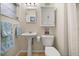 Well-lit bathroom with pedestal sink, toilet, and a mirror above the toilet at 7115 Lake Ola Dr, Mount Dora, FL 32757